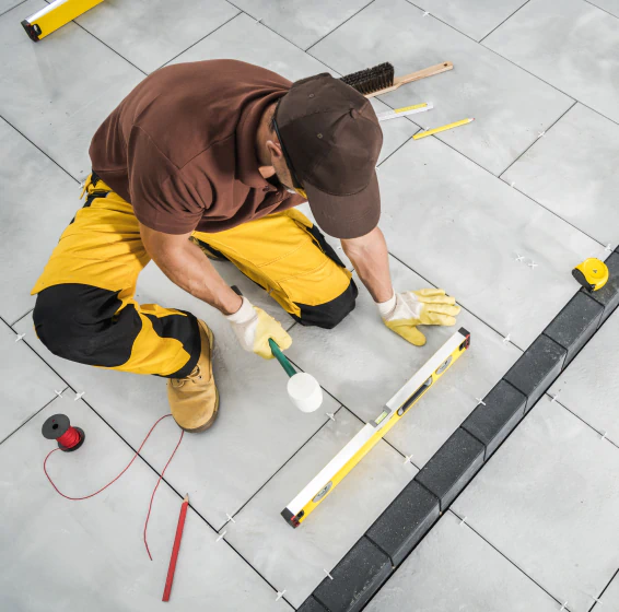 worker installing paving bricks patio floor